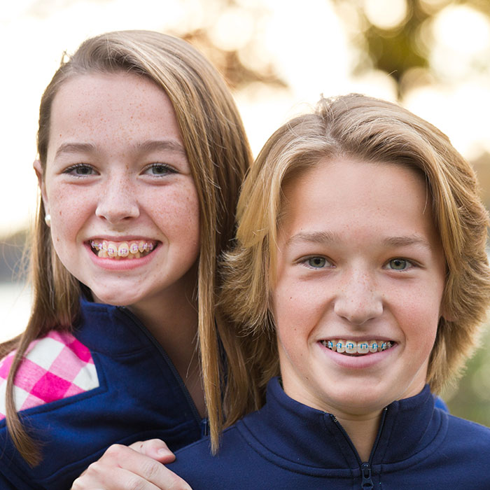 sister and brother both smiling with braces